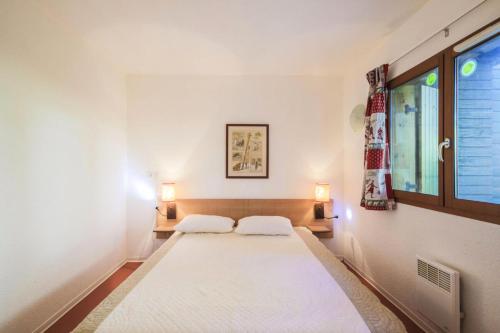 une chambre avec deux lits et une fenêtre dans l'établissement Résidence les Chalets D'aurouze - maeva Home - Appartement 2 Pièces 5 Personnes - Confort MAE-5467, à Saint-Étienne-en-Dévoluy