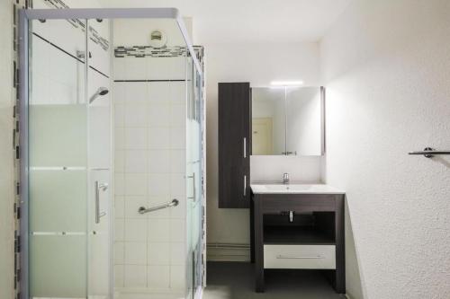 La salle de bains est pourvue d'un lavabo et d'une douche avec un miroir. dans l'établissement Résidence les Chalets D'aurouze - maeva Home - Appartement 2 Pièces 5 Perso 67, à Saint-Étienne-en-Dévoluy