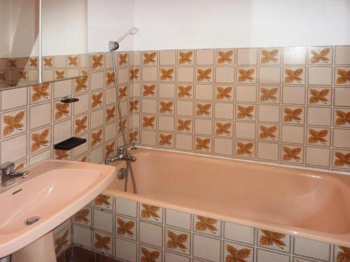 y baño con bañera rosa y lavamanos. en Résidence Les Flocons - 2 Pièces pour 6 Personnes 654 en Le Mélézet