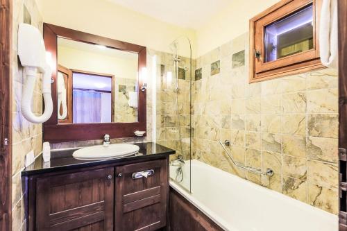 une salle de bain avec une baignoire et un lavabo et une baignoire dans l'établissement Résidence Les Arcs 1950 Le Village - maeva Home - Appartement 3 Pièces 6 Personnes - Sélection MAE-5480, à Bourg-Saint-Maurice