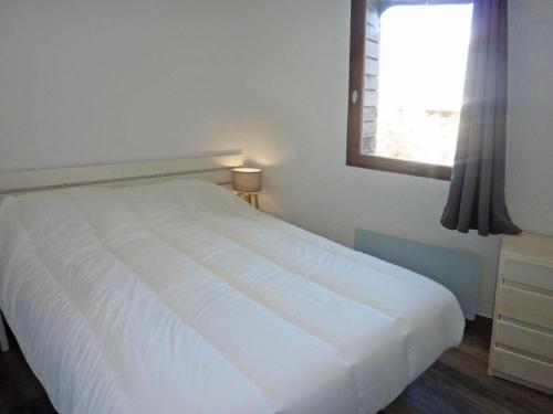 a white bed in a bedroom with a window at Résidence Les Flocons - 2 Pièces pour 6 Personnes 654 in Le Mélézet