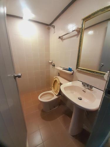 a bathroom with a toilet and a sink and a mirror at Sogo Hotel 2 in Labuan