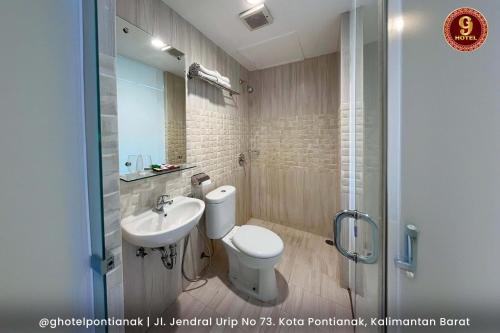 a bathroom with a toilet and a sink and a shower at G-Hotel Pontianak in Pontianak