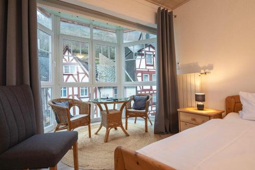 um quarto com uma cama, uma mesa e uma janela em Gästehaus "Ursula" Hotel Garni em Bernkastel-Kues