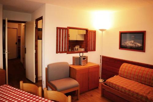 une chambre d'hôtel avec un lit et une chaise dans l'établissement Résidence Le Belvedere - 2 Pièces pour 6 Personnes 864, à Le Mélézet