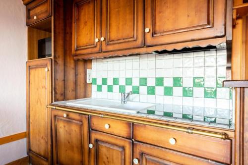 une cuisine avec des armoires en bois et un évier dans l'établissement Résidence Le Roselend - maeva Home - Appartement 2 Pièces 6 Personnes - Sélection MAE-6508, à Bourg-Saint-Maurice