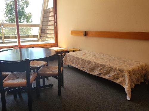 een kamer met een bed, een tafel en een raam bij Résidence Cascade - Studio pour 4 Personnes 19 in Arc 1600