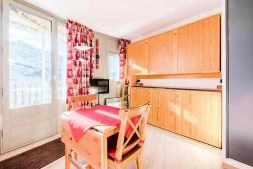 une cuisine avec une table et des chaises dans une pièce dans l'établissement Résidence Les Ruches - maeva Home - Studio 2 Personnes - Confort - Bâtiment Allegro MAE-7437, à Avoriaz
