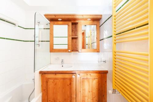 une salle de bain avec un lavabo, une baignoire et un miroir dans l'établissement Résidence Les Hauts Bois - maeva Home - Appartement 3 Pièces 6 Personnes - Sélection MAE-7828, à Aime La Plagne