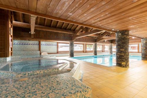 une grande piscine dans un immeuble dans l'établissement Résidence Les Fermes du Soleil - maeva Home - Appartement 3 pièces 6 personnes - Sélection MAE-8004, aux Carroz d'Arâches