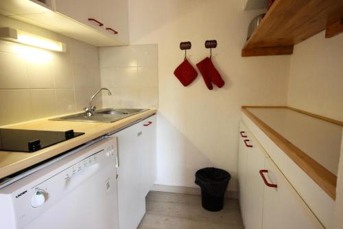 a small white kitchen with a sink and a counter at Résidence Grande Ourse - 2 Pièces pour 4 Personnes 40 in Peisey-Nancroix