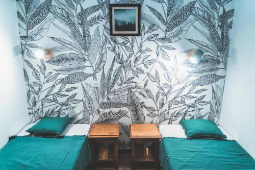 Cette chambre comprend 2 lits et un mur orné d'une fresque murale. dans l'établissement Résidence Les Eglantines - appartement 6 personnes en plein cœur des orres 1800 MAE-4804, aux Orres