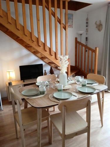 une table en bois avec des chaises et une salle à manger dans l'établissement Résidence Les Terrasses Du Soleil D'or - 3404 TERRASSES DU SOLEIL D'OR, LES ORRES 1800 MAE-4884, aux Orres