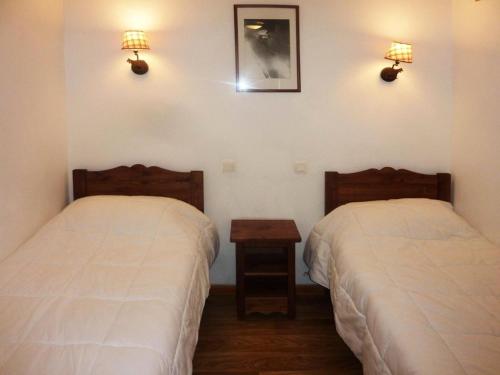 - une chambre avec 2 lits, une table et des lumières dans l'établissement Résidence Les Erines - 1305 ERINES LES ORRES 1800 MAE-4834, aux Orres