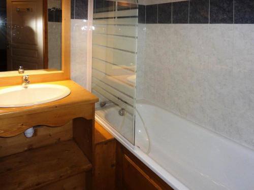 une salle de bain avec un lavabo et une baignoire dans l'établissement Résidence Les Erines - 1305 ERINES LES ORRES 1800 MAE-4834, aux Orres