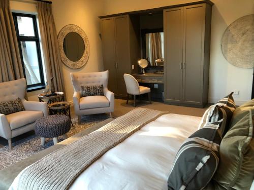 1 dormitorio con cama, sillas y escritorio en Santé Wellness Retreat & Spa en Paarl