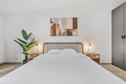 a bedroom with a large white bed with two lamps at Charming Clausen Getaway ID209 in Luxembourg