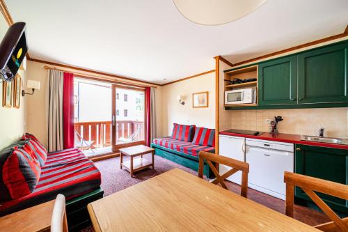 une cuisine et un salon avec une table et un canapé dans l'établissement Résidence L'Alpaga - maeva Home - Appartement 2 Pièces 5 Personnes - Budget MAE-4574, à La Salle Les Alpes
