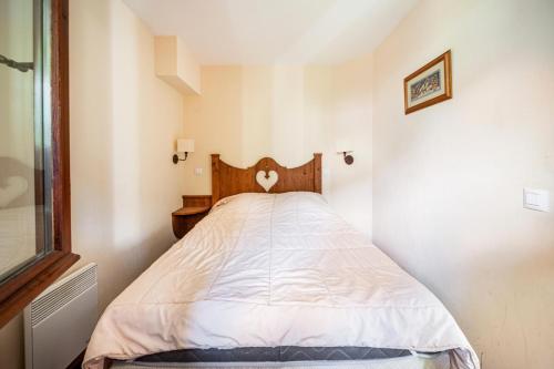 Cette petite chambre comprend un lit avec des draps blancs. dans l'établissement Résidence L'Alpaga - maeva Home - Appartement 2 Pièces 5 Personnes - Budget MAE-4574, à La Salle Les Alpes