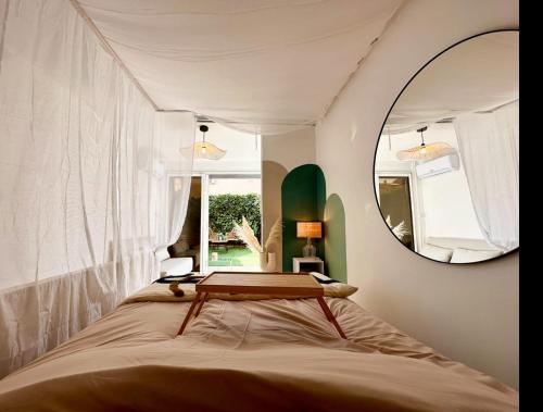 カップ・ダグドにあるSuper Mini Loft avec Cinéma et Jardin - Cap d'Agdeのベッドルーム(ベッド1台、鏡付)