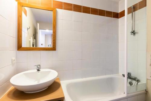 une salle de bain avec un lavabo, une baignoire et un miroir dans l'établissement Résidence Plagne Lauze - maeva Home - Appartement 3 Pièces 7 Personnes - Prestige MAE-0834, à Mâcot La Plagne