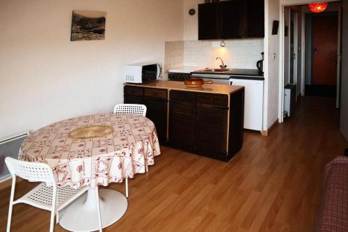 une cuisine avec une table et des chaises dans une pièce dans l'établissement Résidence Les Carlines - Studio 4 personnes 1650 MAE-6174, aux Orres