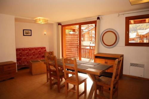 une salle à manger avec une table et des chaises en bois dans l'établissement Résidence Parc Des Airelles - Rare à la location appartement 10 personnes 102m² MAE-7344, aux Orres