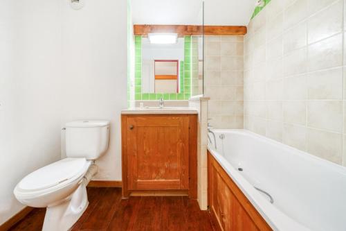 une salle de bain avec toilettes, baignoire et lavabo dans l'établissement Résidence L'Alpaga - maeva Home - Appartement 3 pièces 8 Personnes - Budget MAE-2474, à La Salle Les Alpes