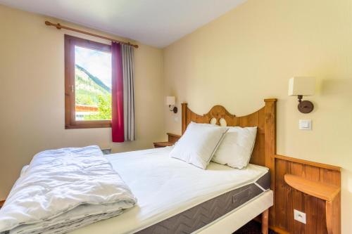 une chambre avec un grand lit avec une fenêtre dans l'établissement Résidence L'Alpaga - maeva Home - Appartement 2 Pièces 5 Personnes - Budget MAE-2484, à La Salle Les Alpes