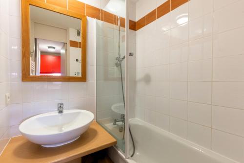 une salle de bain avec un lavabo, un miroir et une baignoire dans l'établissement Résidence Plagne Lauze - maeva Home - Studio 4 personnes - Sélection MAE-1114, à Mâcot La Plagne