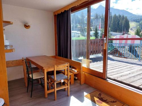 Cette chambre dispose d'un balcon avec une table et des chaises en bois. dans l'établissement Résidence Nova - Appartement 3 pièces 7 personnes, proche des pistes, des commerces, de la garderie et de l'ESF au centre de la station d’Arc 180 MAE-2174, à Arc 1800