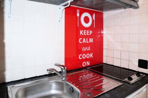 - un évier de cuisine avec un panneau de cocacola sur le mur dans l'établissement Résidence Les Gradins - Grand studio pour 4 personnes MAE-2664, aux Orres