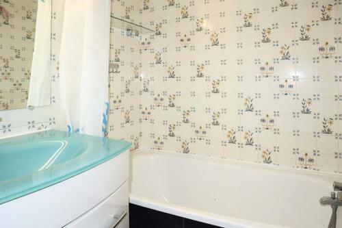 une salle de bain avec une baignoire et un lavabo dans l'établissement Résidence Les Gradins - Grand studio pour 4 personnes MAE-2664, aux Orres