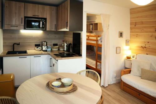 Il comprend une cuisine et un salon avec une table. dans l'établissement Résidence Aupillon - LES ORRES 1650 APPARTEMENT 4 PERSONNES MAE-4134, aux Orres