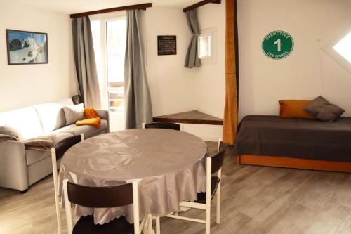 Cette chambre comprend une table, un lit et un canapé. dans l'établissement Résidence Le Boussolenc - Studio équipé pour 4 personnes MAE-4144, aux Orres