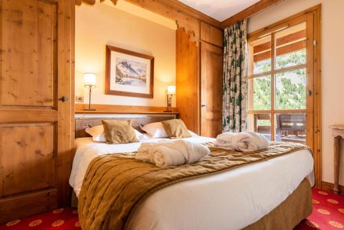 - une chambre avec deux chiens dormant sur un lit dans l'établissement Résidence Les Arcs 1950 Le Village - maeva Home - Appartement 3 Pièces 6 Personnes - Prestige MAE-4044, à Bourg-Saint-Maurice