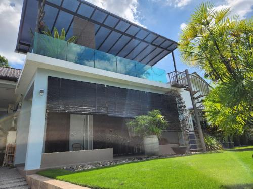 a house with a glass facade with a spiral staircase at Lovell 63 in Puchong