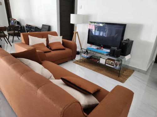 ein Wohnzimmer mit einem Sofa und einem Flachbild-TV in der Unterkunft Lovell 63 in Puchong