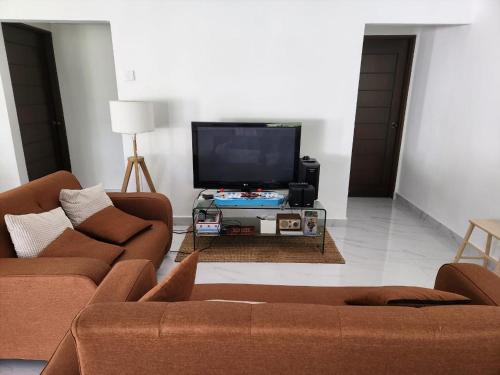a living room with two couches and a flat screen tv at Lovell 63 in Puchong
