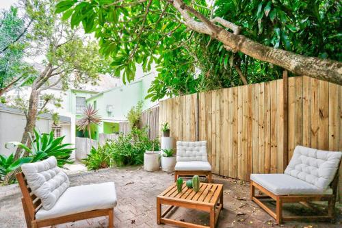 a patio with two chairs and a table and a fence at Elegant 2 BR on the edge of Downtown Dowling St 2 E-Bikes Included in Sydney