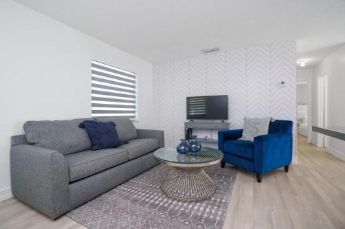a living room with a couch and a table and a tv at Blue Door Duplex Renovated Parking and Designed in Cutler Bay
