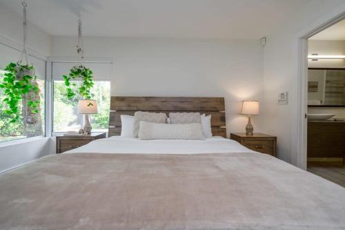 a white bedroom with a large bed and two lamps at Boho House - Stylist Home with Parking and large Yard in Miami