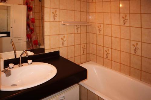 bagno con lavandino e vasca di Résidence Pic Vert - Studio pour 4 Personnes 204 a Les Orres
