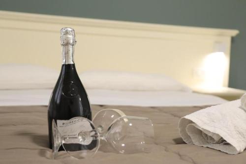 una botella de vino y copas en una mesa en B&B Allison Tropea en Tropea