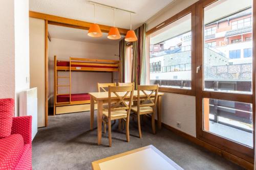 une salle à manger avec une table et des chaises et une fenêtre dans l'établissement Résidence Les Chalets des Arolles - maeva Home - Studio 4 Personnes - Budget MAE-5804, à La Plagne Tarentaise