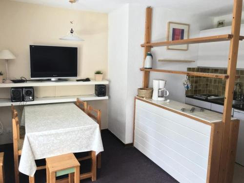 - une petite cuisine avec une table et une télévision dans la chambre dans l'établissement Résidence Le Meale - CENTRE STATION Les Orres 1650 - Rés. LE MEALE - Studio 4 Pers. MAE-3881, aux Orres