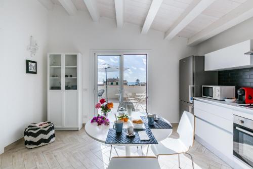 a kitchen and dining room with a table and chairs at Donnalucata Ospitalità Diffusa in Donnalucata