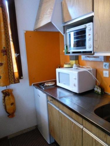 a kitchen with a microwave and a counter top at Résidence Le Pouzenc - Studio pour 4 Personnes 901 in Les Orres