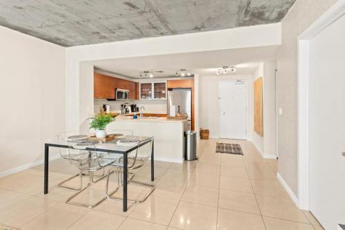 a kitchen and dining room with a glass table at Urban Retreat - Location Pool Gym & Parking in Miami
