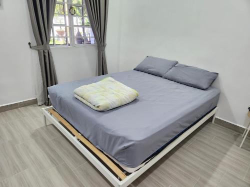Bett in einem Zimmer mit Fenster in der Unterkunft Lovell 63 in Puchong